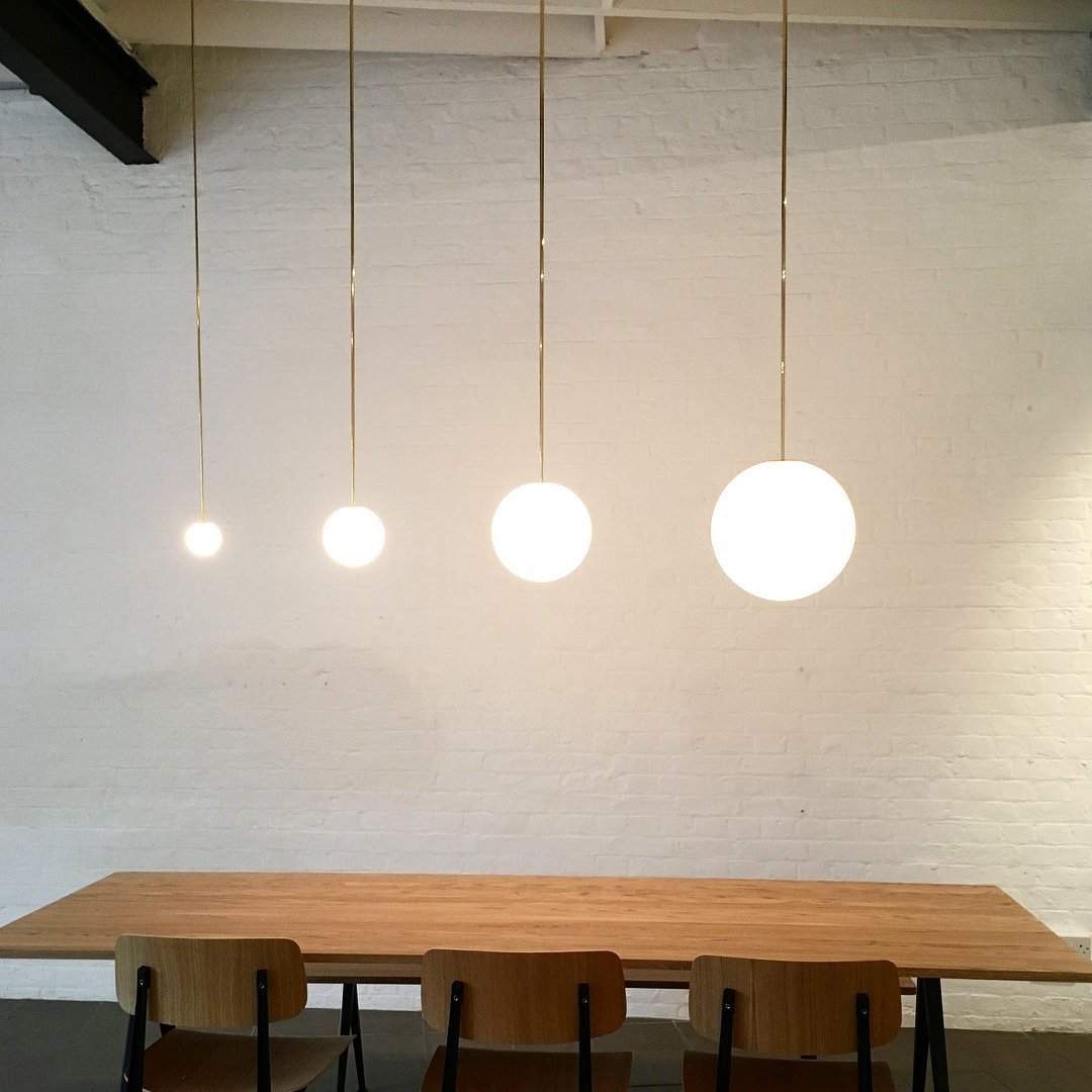 Minimalist pendant light made of brass and milk glass, featuring a 30 cm diameter. Ideal for dining rooms and hallways. 4